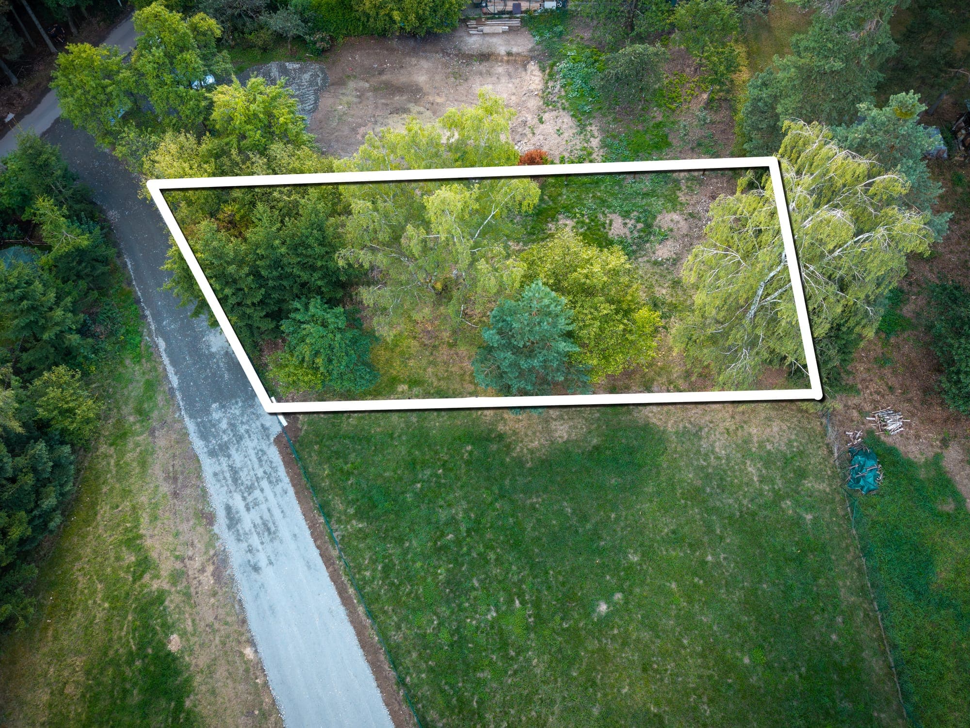 Parcela se vzrostlými stromy z dronu s vyznačenou hranicí